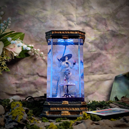 Decorative lamp with a figure inside, surrounded by flowers and foliage on a textured background