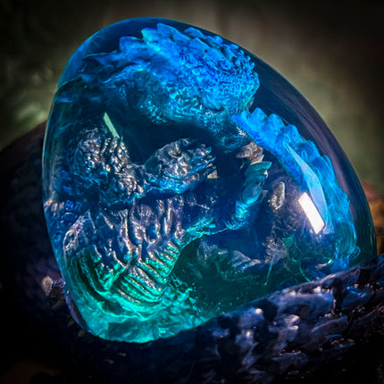 Close-up of Godzilla hatching egg resin lamp with multi-color LED lighting.
