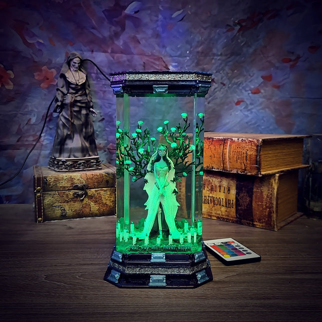 Decorative lamp with green light effects on a wooden surface, surrounded by books and a statue.