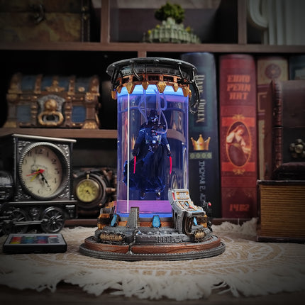 Decorative figurine with a blue figure inside a glass dome on a table with books and decorative items in the background.