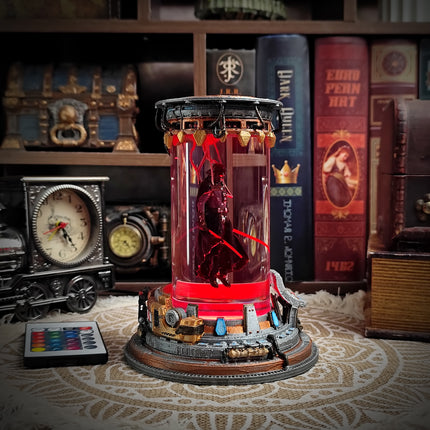 Decorative cylindrical object with a figure inside, surrounded by books and decorative items on a shelf.