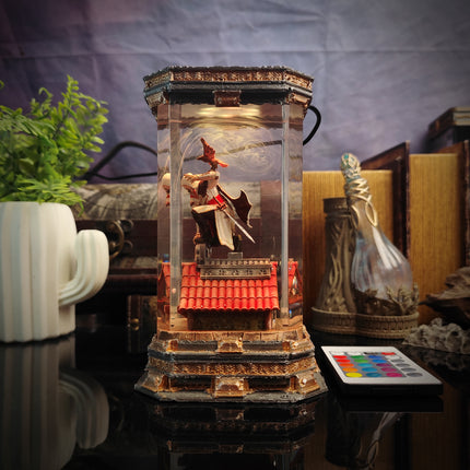 Decorative lamp with birds inside a glass enclosure on a table.