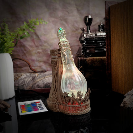 Decorative bottle with a glowing interior on a table, with a plant and vintage camera in the background.