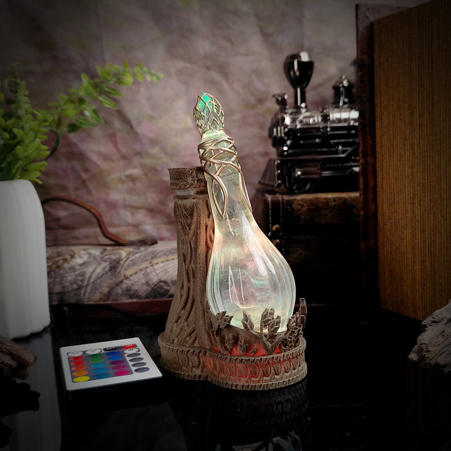 Decorative bottle with a glowing interior on a table, with a plant and vintage camera in the background.