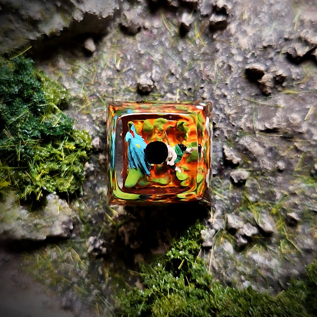 Decorative glass block with colorful design on a natural stone and moss background