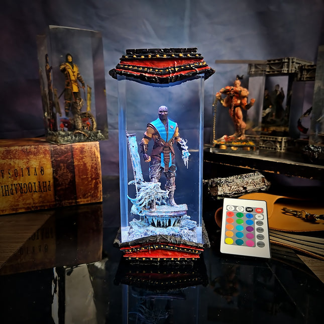 Light-up figurine in a transparent display case with remote control on a reflective surface.