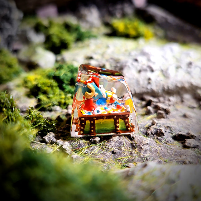 Small glass figurine with colorful interior on a natural rock background